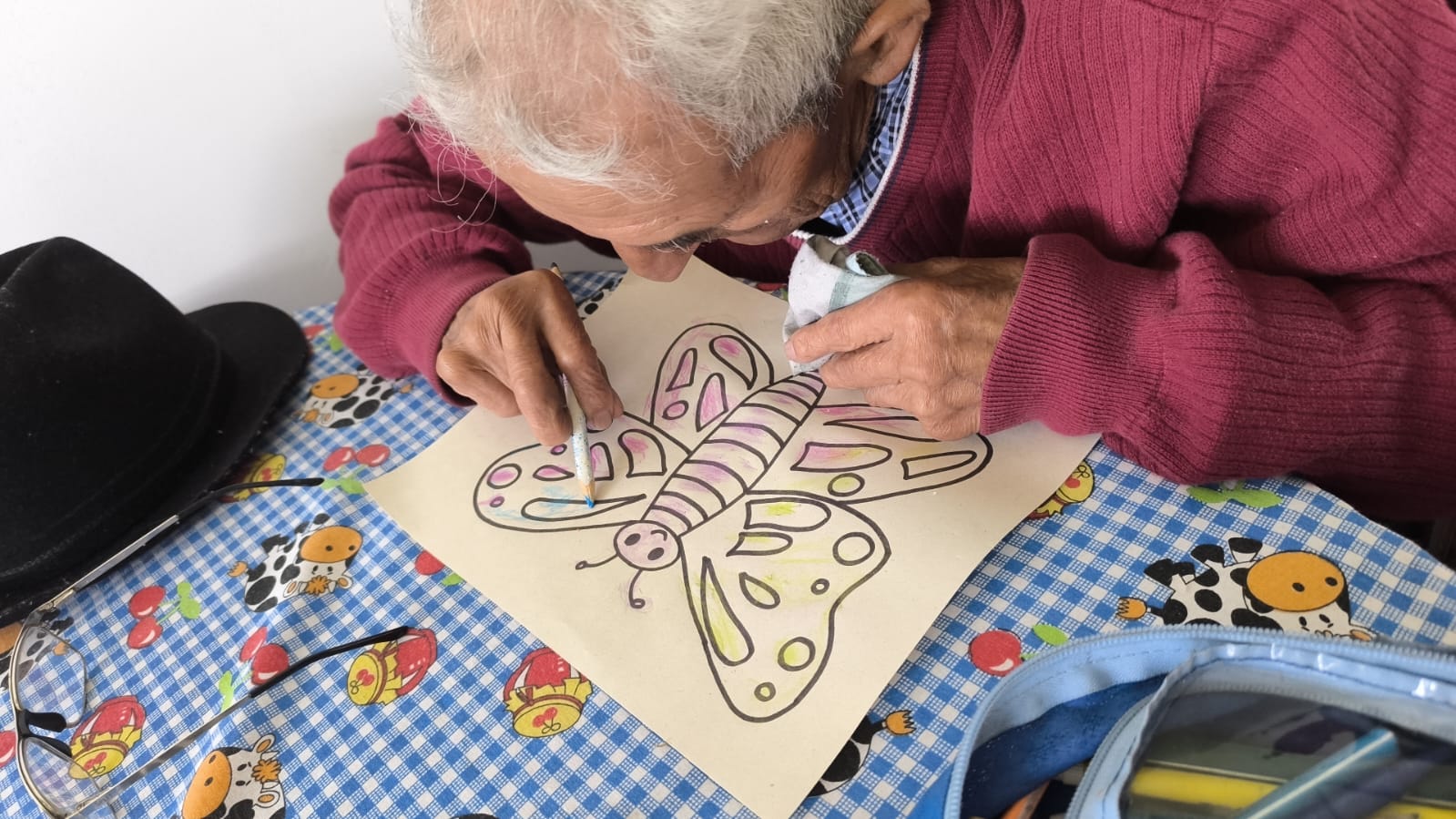 Residente pintando una mariposa en un taller de arte