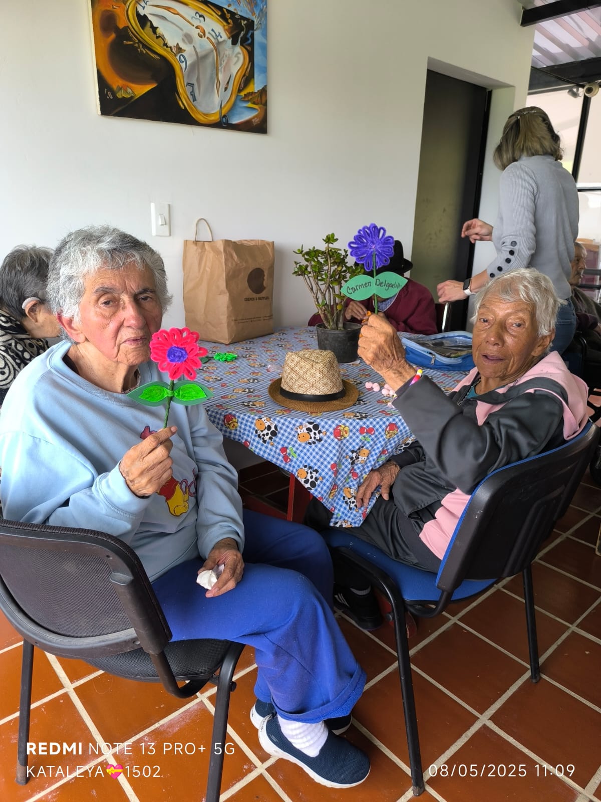 Residentes compartiendo en una actividad con flores de papel