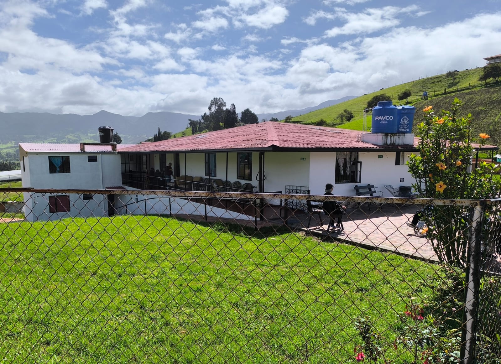 Vista del hogar con su jardín y las verdes montañas de la sabana
